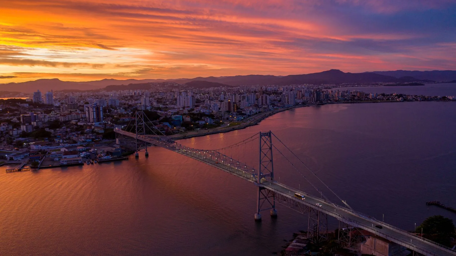 El puente Hercílio Luz al atardecer, con el centro de Florianópolis de fondo